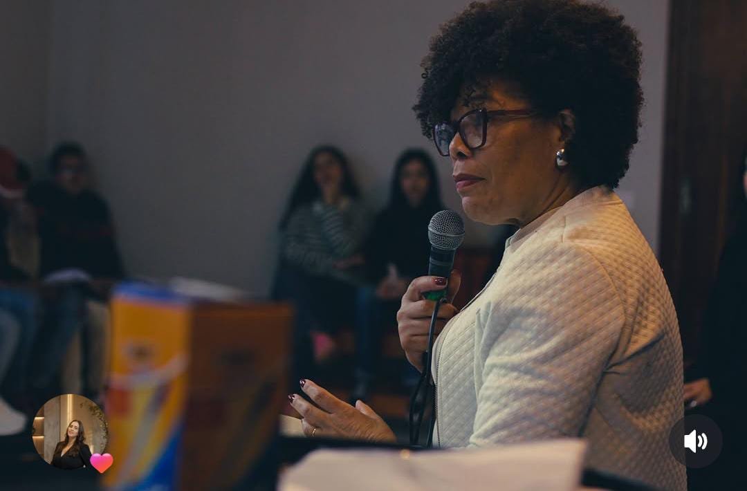 Vanusa Santos falando ao microfone durante um evento